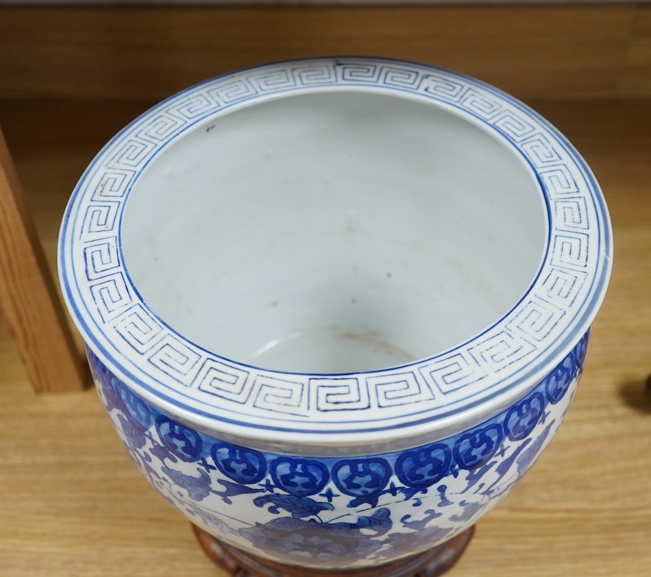 A Chinese blue and white floral jardiniere on hardwood stand, overall 32cm high. Condition - good